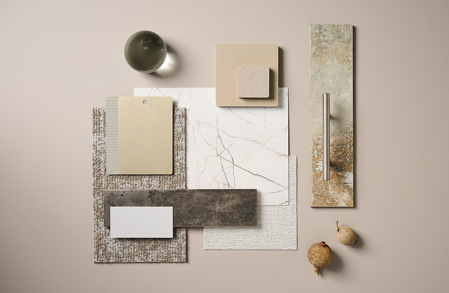 Rectangular samples of brown, tan, metallics and marbles arranged in a designer’s palette alongside a glass orb and dried seedpods