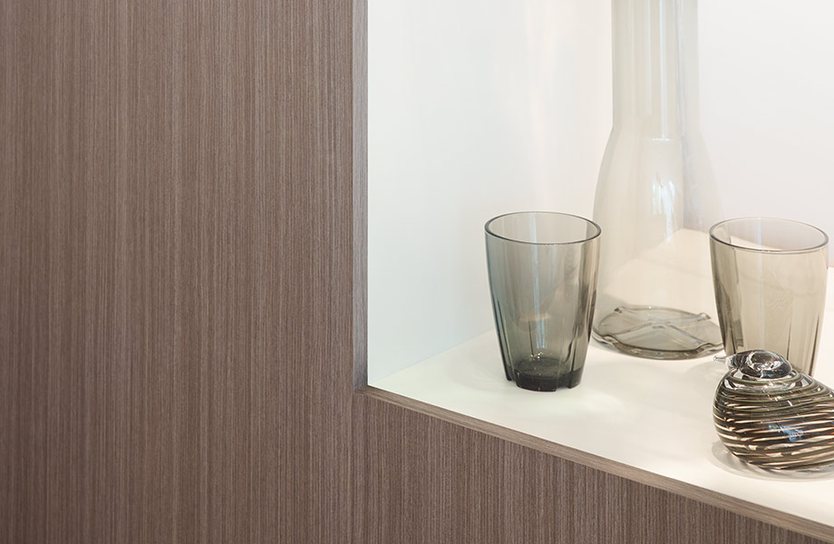 Silver Riftwood Formica Laminate wall panel with shelf holding glassware framed in white Surf Formica Laminate
