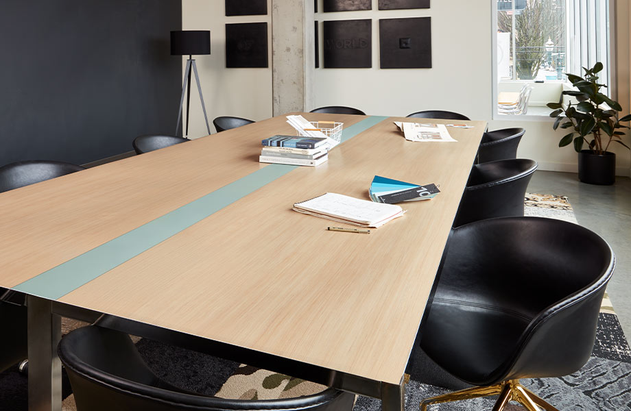 A stylistic boardroom table with black chairs