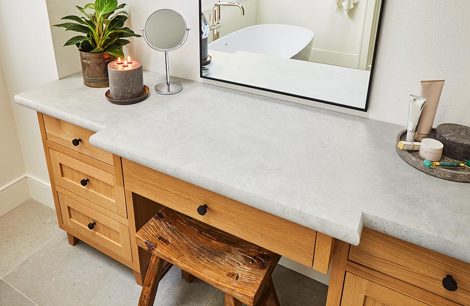 Meuble de salle de bain contemporain avec comptoir gris clair en stratifié de marque Formica Patine de Craie, tabouret, plante et miroir